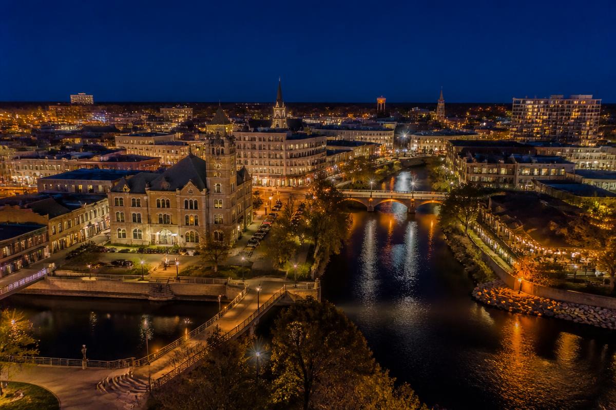 Cinematic aerial view of downtown Waukesha Wisconsin at dusk along the Fox River